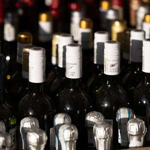 Red wines stacked on a shelf right to left 