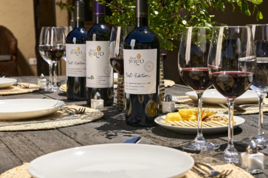 Table with bottles of Valle Secreto and two cups of wine