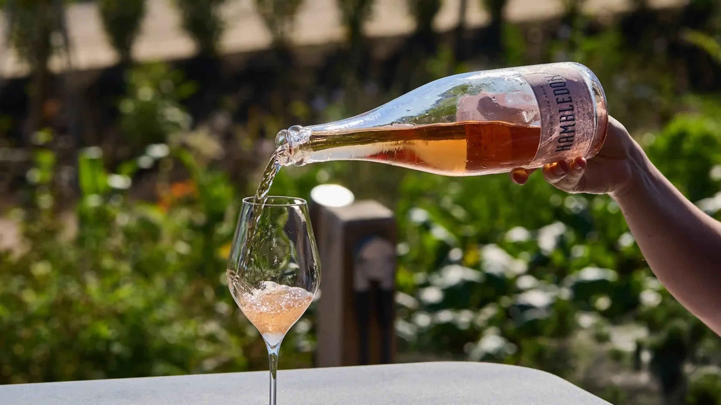 rose being poured into a wine glass on the terrace 