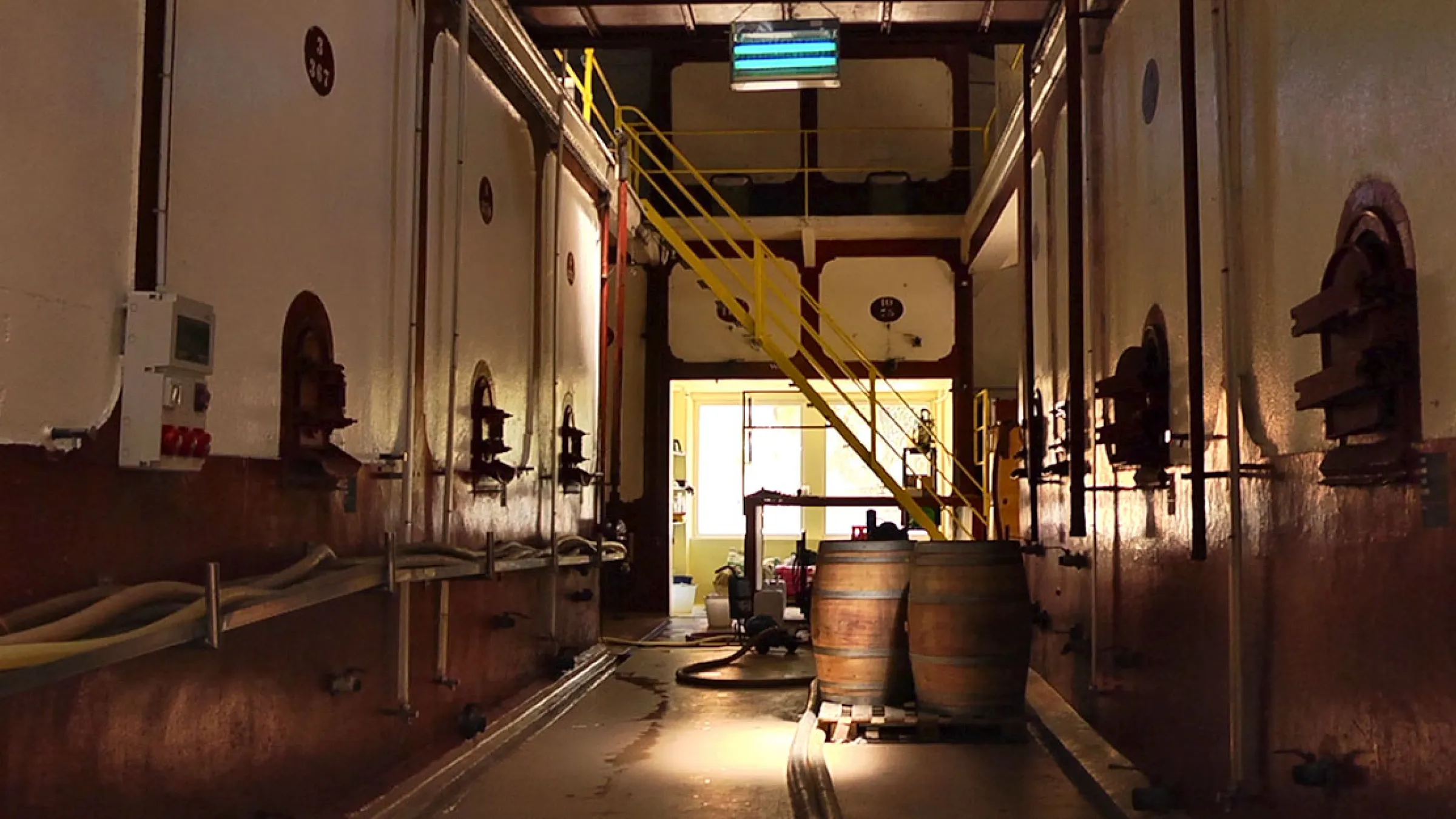Insider view of a production room, with barrels and stairs