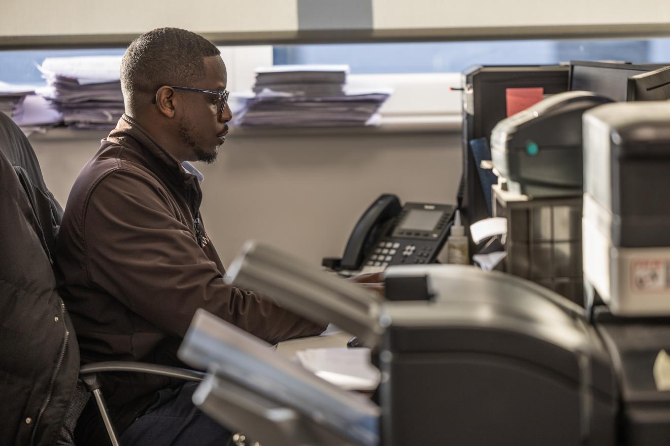 Theo creating menus for customers on his computer 